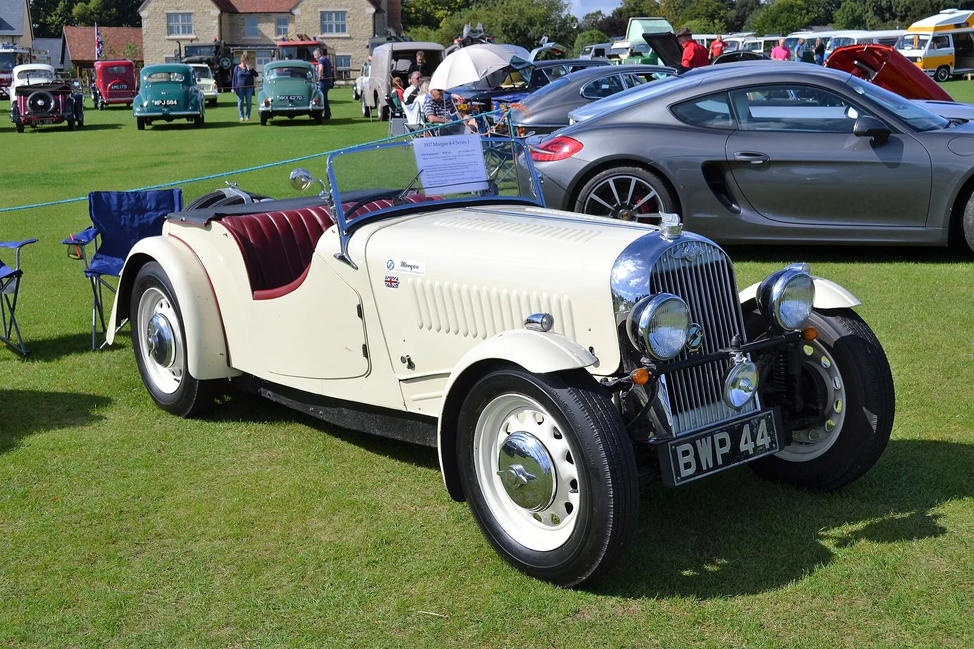 A pale-blue 1937 Morgan 4-4 Series 1 two-seater parked on grass among other cars