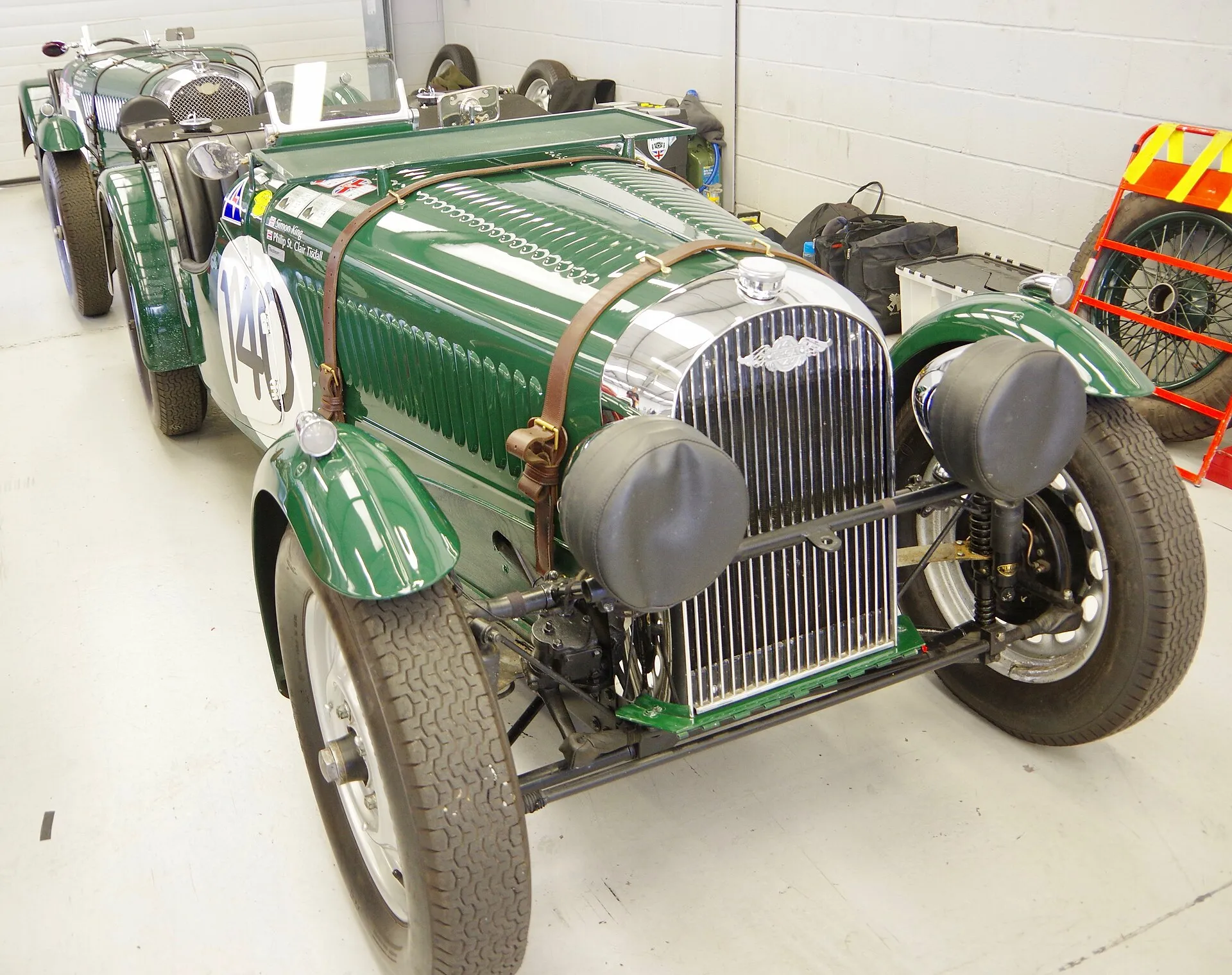 A green 1937 Morgan 4-4 in Le Mans trim on a circuit, seen from the front