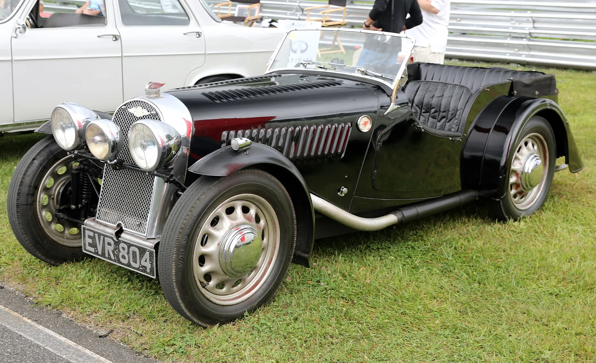 A dark-green 1938 Morgan 4-4 Le Mans Replica four-seater on a lawn, seen from the front