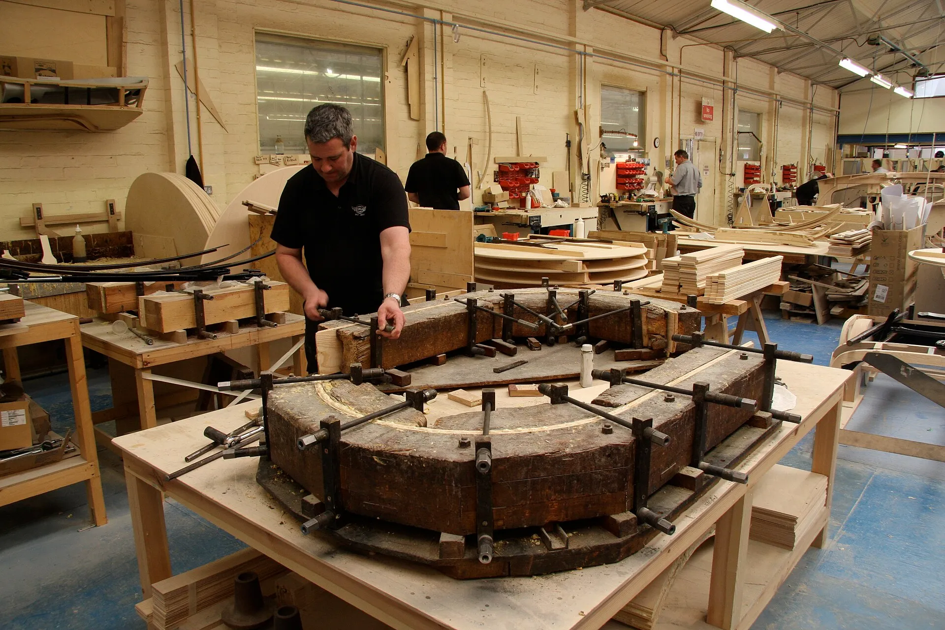 A Morgan worker shaping the wooden inner structure of a wheel arch in the factory