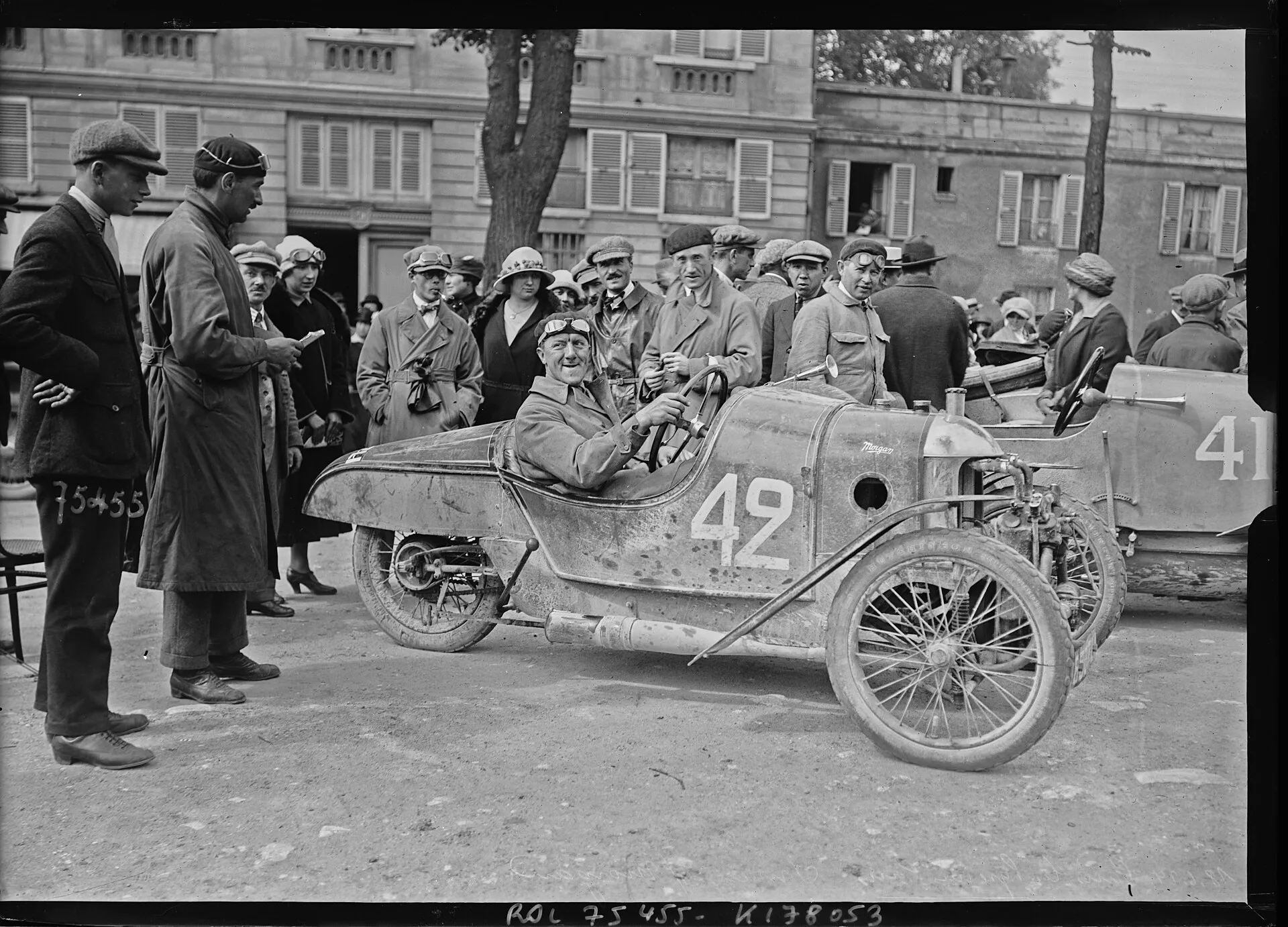 A black-and-white press photograph of a Morgan cyclecar, number 42, among a crowd at the finish of a road race