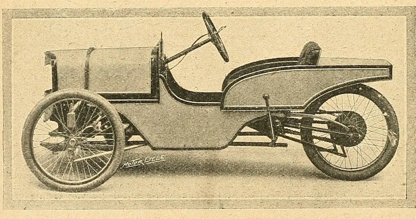 A grainy 1911 photograph of a single-seat Morgan Runabout from the side: a long two-tone body, tiller-style steering wheel, two front wheels and one rear wheel