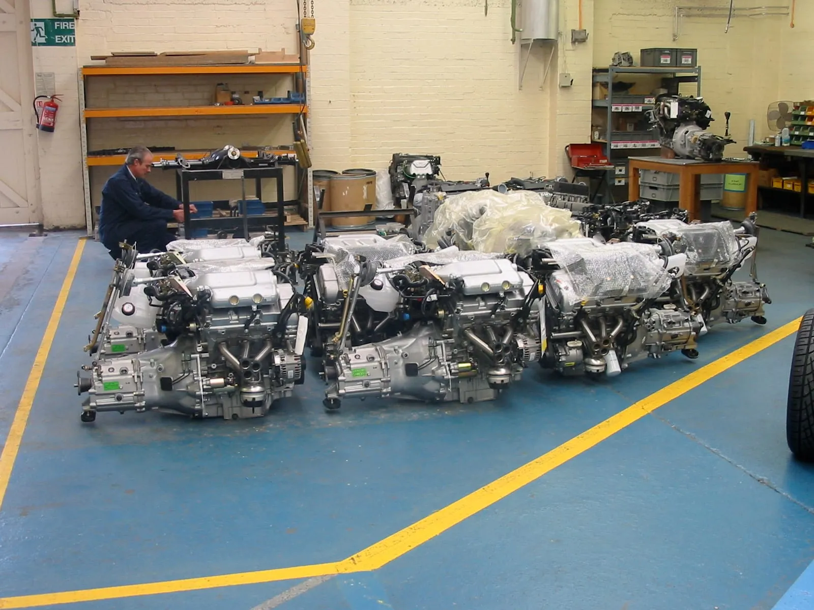 Rows of V6 engines on the workshop floor, a man at work among them